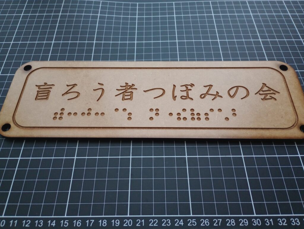 完成した名標。文字「盲ろう者つぼみの会」を大きく、その下に点字も彫ってある。